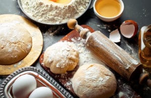 dough with flour on an old background in a composition with kitchen accessories